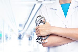 Doctor with stethoscope on blurred hospital background.